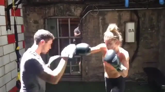 Eric holding pads for Nina Agdal during a boxing session